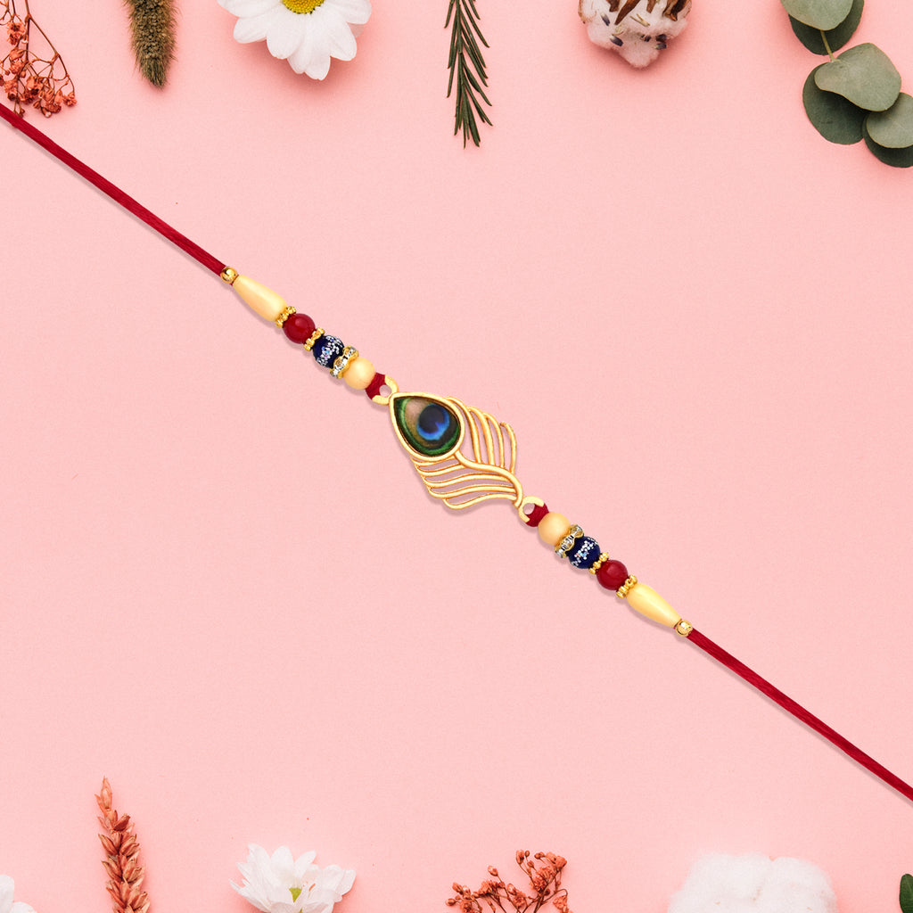 Peacock Feather Design Rakhi With Beaded Detailing And Red Thread